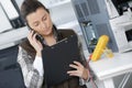 Female technician with clipboard talking on phone Royalty Free Stock Photo