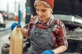 Female technician holding a plastic engine oil bottle