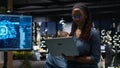 Female technician in office using laptop to fix artificial intelligence bugs Royalty Free Stock Photo