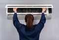 Female technician service open air conditioner indoor for checking and repairing
