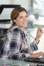 female technician using laptop and holding eyeglasses