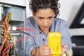 female technician using voltage meter for voltage measurement Royalty Free Stock Photo