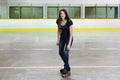 Female teen doing t stop on quad roller skates