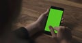 Female teen girl using smartphone with green screen sitting at the table Royalty Free Stock Photo