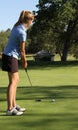 Female teen golfer putting on green Royalty Free Stock Photo