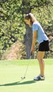 Female teen golfer putting home Royalty Free Stock Photo