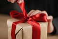 Female teen hand going to untie bow on gift box