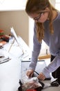 Female Teenage Artist Framing Picture In Studio