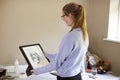 Female Teenage Artist Holding Framed Charcoal Drawing Of Dog In Studio Royalty Free Stock Photo