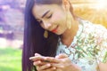 Female teenager so cute using smartphone happily in park