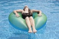 Female teenager floating on float in pool