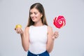 Female teenager holding apple and lollipop Royalty Free Stock Photo