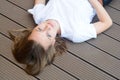 Female teenager smiling, layingon the floor. Summer, portrait of young girl with long, blonde hair Royalty Free Stock Photo