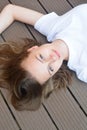 Female teenager smiling, layingon the floor. Summer, portrait of young girl with long, blonde hair Royalty Free Stock Photo