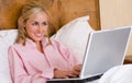 Female teenager or Young Woman Using Laptop Computer in Bed Royalty Free Stock Photo