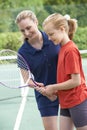 Female Tennis Coach Giving Lesson To Girl