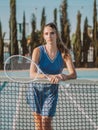 Female tennis player on a court standing near net with racket in her hands Royalty Free Stock Photo