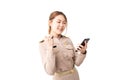 Female Thai government officer in khaki uniforms smiling and holding smartphone on white background. Cheerful beautiful asian
