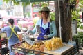 Female thai street vendor selling sliced pineapple in Bangkok, Thailand