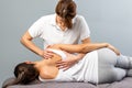 Female therapist manipulating shoulder blade on young female pat Royalty Free Stock Photo