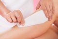 Female therapist waxing customer's leg at spa