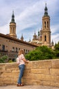 Female tourist admiring the high towers of the cathedral basilica of El Pilar in the monumental city of Zaragoza, Spain. Royalty Free Stock Photo