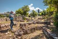 Female tourist in Ancient Agora, Athens, Greece. Young pretty woman photographs classical Greek ruins in Athens city center