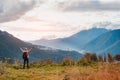 female tourist with a backpack in autumn on the mountain with outstretched arms welcomes admires the sunset Royalty Free Stock Photo