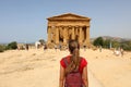 Female tourist with backpack visiting Concordia temple in the Valley of temples near Agrigento in Sicily, Italy Royalty Free Stock Photo