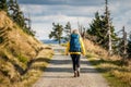 Female tourist with backpack walks on trekking trail in mountain