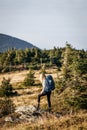 Female tourist with backpack walks on trekking trail in mountain