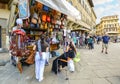 A woman shops for souvenirs from a small shop stand selling leather goods and clothing in Piazza Santa Croce in Florence Italy Royalty Free Stock Photo