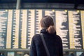 Female tourist looking at flight schedules for checking take off time. Generative AI