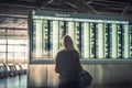 Female tourist looking at flight schedules for checking take off time. Generative AI