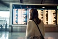 Female tourist looking at flight schedules for checking take off time. Generative AI