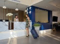 Female tourist with carry on luggage standing at hotel reception counter. Travelling, holiday and vacation concept Royalty Free Stock Photo