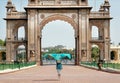 Female tourist in colorful clothing and romantic mood walking to the gates of famous royal Palace of Mysore. India