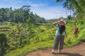 Female tourist enjoying the stepwise green rice field nature in a sunny day in Ubud, Bali