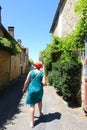 A female tourist exploring the back streest of the bastide town of Domme in the French Dordogne region