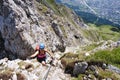 Female tourist on exposed ridge above Innsbruck, the Nordkette via ferrata klettersteig in Austria. Wooden bridge, active.