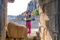 Female tourist filming the ruins of antique amphitheater and famous rocky necropolis in Myra Demre, Turkey Royalty Free Stock Photo