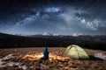 Female tourist have a rest in her camp at night under beautiful sky full of stars and milky way Royalty Free Stock Photo