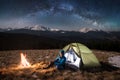 Female tourist in her camp at night. Happy woman under beautiful sky full of stars and milky way Royalty Free Stock Photo