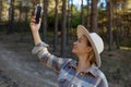 female tourist holds in her hand a smartphone search signal in the forest