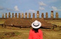 Female tourist impressed by the ruins of Moai statues at Ahu Tongariki on Easter Island archaeological site, Chile