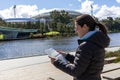 Female tourist looking at a map in front of the Adelaide Oval, next to river Torrens. Sports stadium used for cricket, Australian Royalty Free Stock Photo