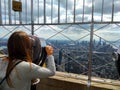 A female tourist looking at the skyscrapers of Manhattan from the observation deck of the Empire State Building in New York Royalty Free Stock Photo