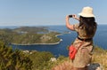 A female tourist makes a photo on a smartphone on the island of