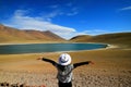 Female tourist raising her arms admiring the amazing deep blue lagoon Laguna Miniques, Chile