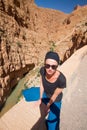 Image of female tourist relaxing on winding road bank in Dades Valley, Atlas mountains, Morocco. Royalty Free Stock Photo